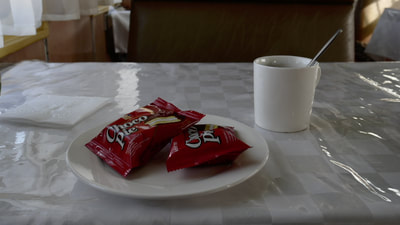 Zwei abgepackte Minikuchen und eine Tasse Kaffee auf dem Tisch im Bistrowaggon als Frühstück