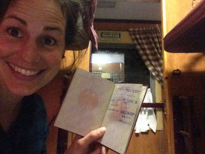 Janina hält ihren Reisepass mit den Stempeln in die Kamera