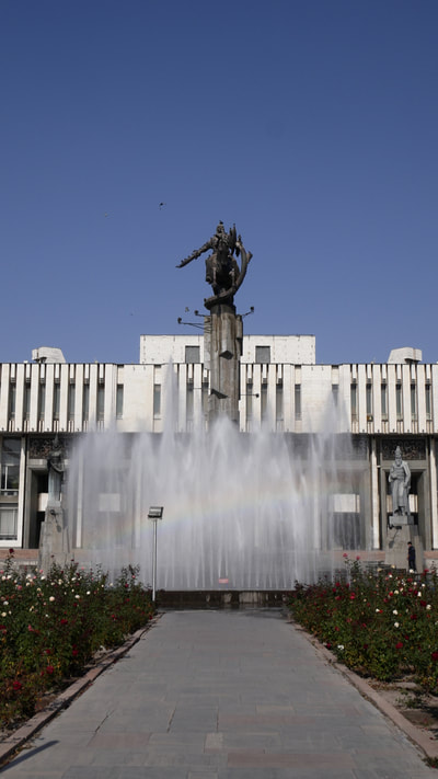 Philharmonie in Bischkek mit einem Regenbogen am Springbrunnen davor