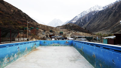 Leeres Schwimmbecken in Issyk-Ata mit Bergen im Hintergrund